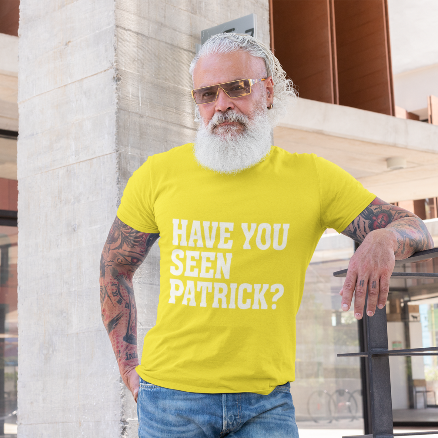 Man wearing a yellow t-shirt with 'HAVE YOU SEEN PATRICK?' text, standing outdoors.