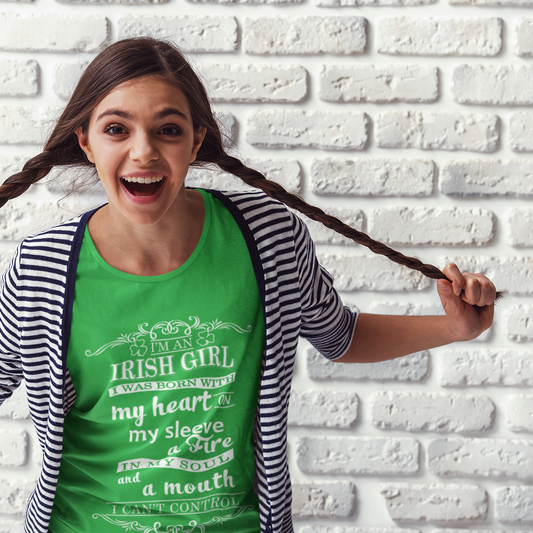 Woman with pigtails wearing a green t-shirt against a white brick wall