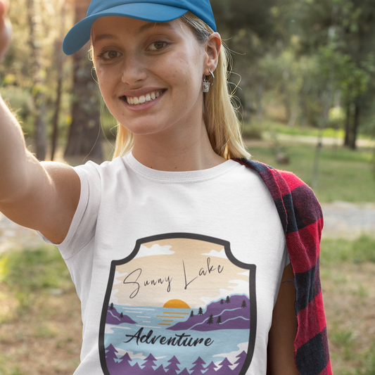 Woman wearing a white t-shirt with a nature-themed graphic and text, standing outdoors.