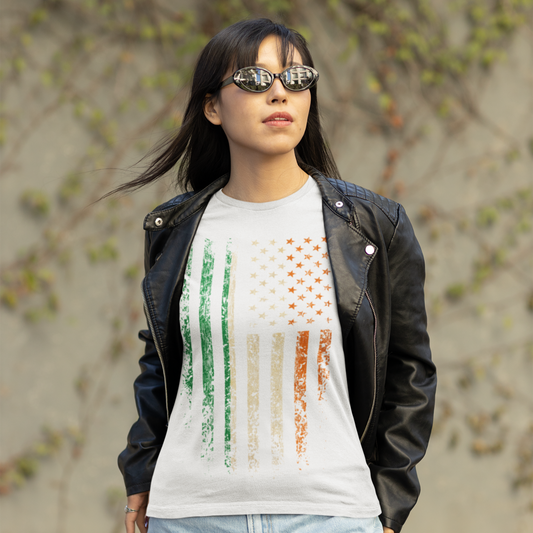 Woman wearing a white t-shirt with colorful design, black leather jacket, and denim shorts outdoors.