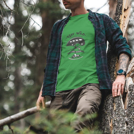 Person wearing a green t-shirt with a graphic design in a forest setting