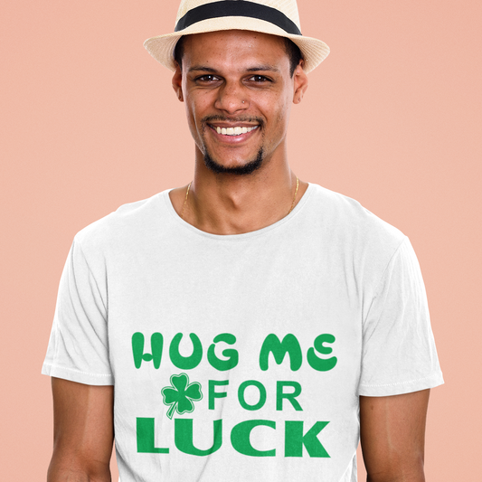Man wearing a white t-shirt with 'Hug Me For Luck' text and a hat on a peach background
