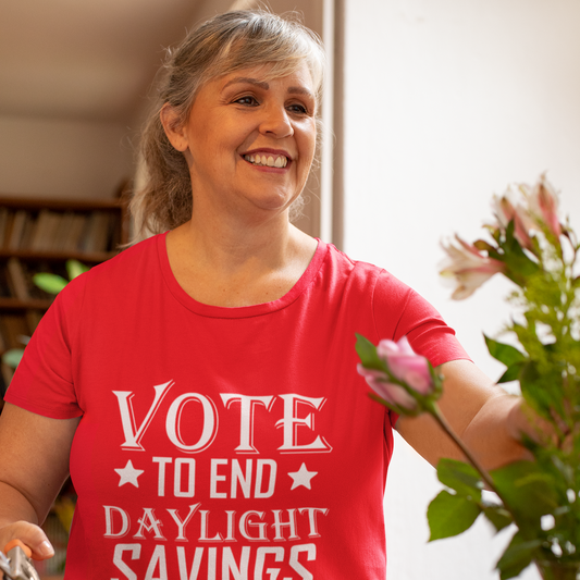 Person wearing a red 'Vote to End Daylight Savings' t-shirt in a kitchen setting.