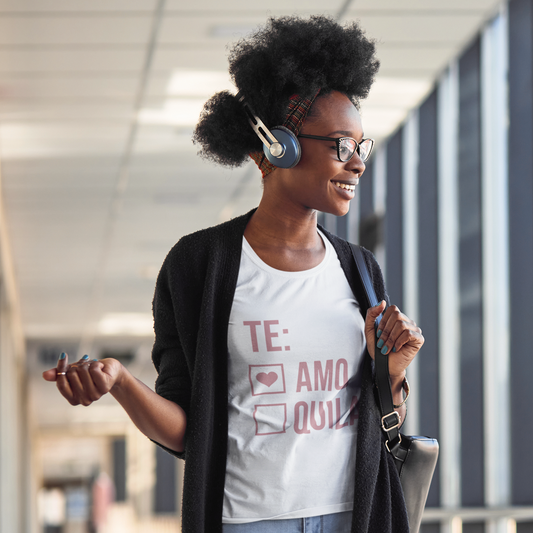 Woman wearing headphones and a white t-shirt with text, standing in an indoor setting.