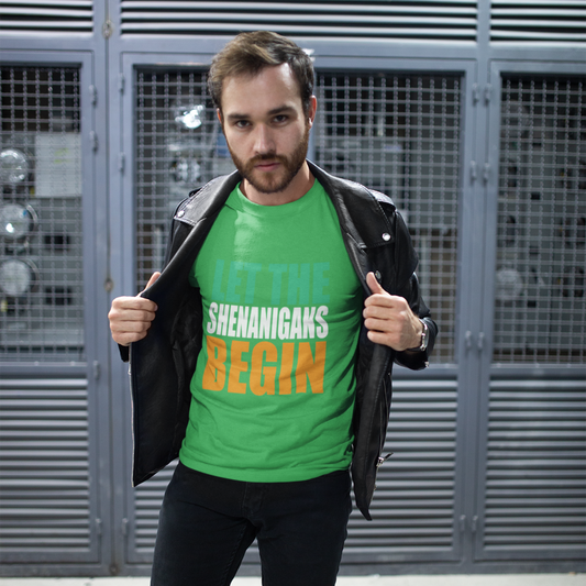 Man wearing a green t-shirt with text, standing in front of a metallic wall.