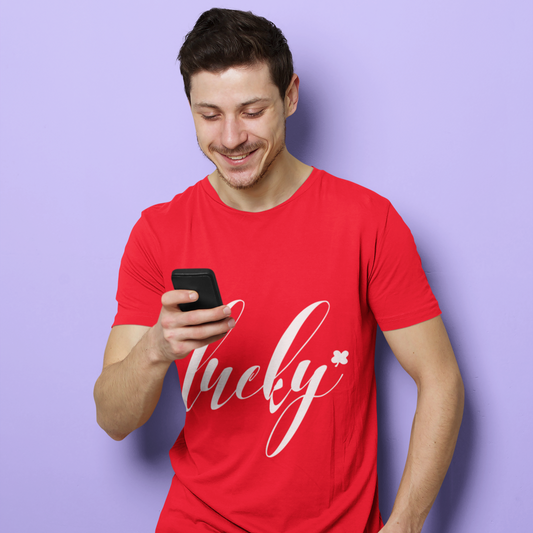 Man wearing a red t-shirt with 'lucky' text, holding a phone against a purple background