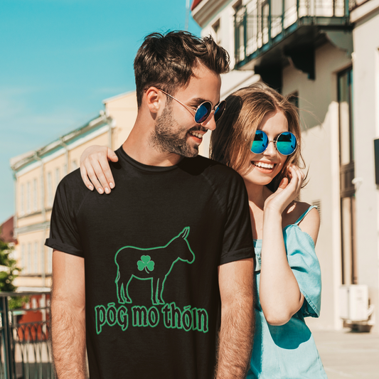 Man wearing a black t-shirt with a green graphic and text, standing next to a woman in a blue dress outdoors.