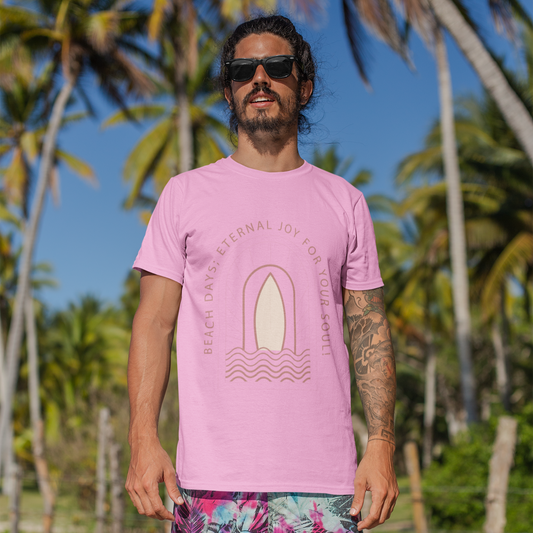 Man wearing a pink t-shirt with a graphic design and colorful shorts standing on a beach with palm trees in the background.