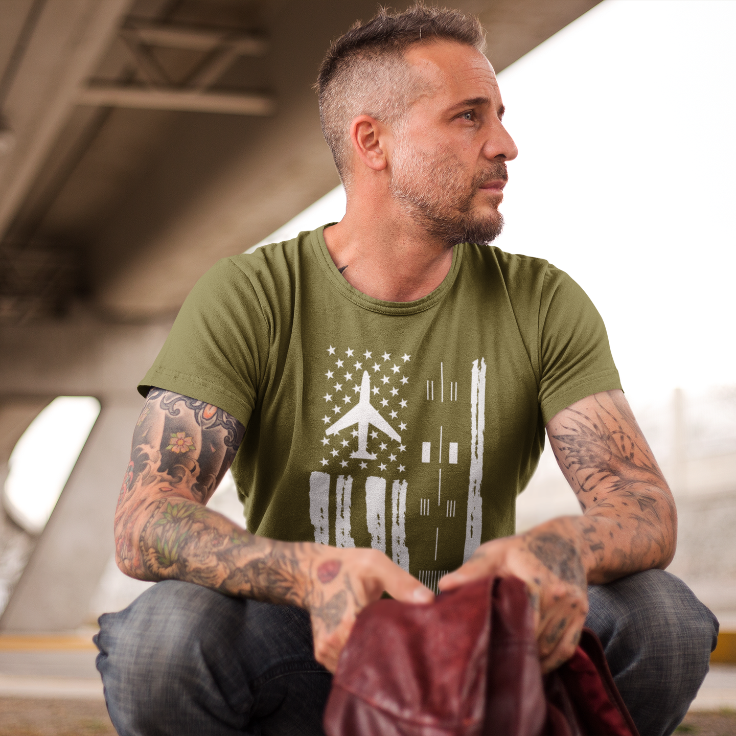 Man wearing a green t-shirt with a graphic design, sitting on a bench.