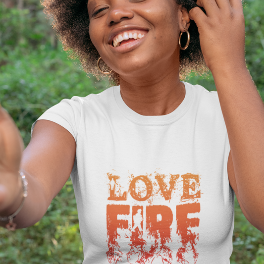 Woman wearing a white t-shirt with 'LOVE FIRE FIGHTER' text, standing outdoors.