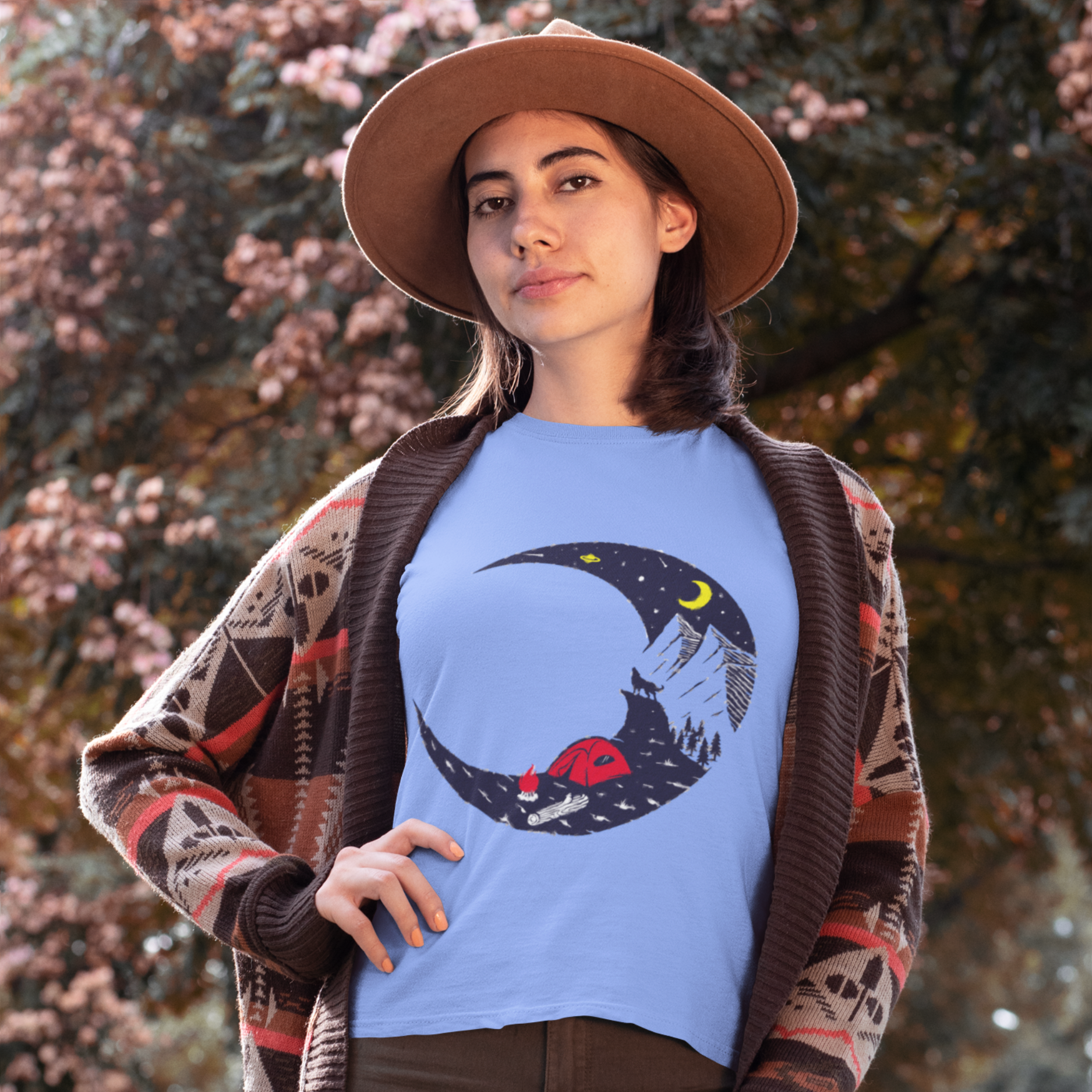 Woman wearing a blue t-shirt with a moon and star design outdoors.