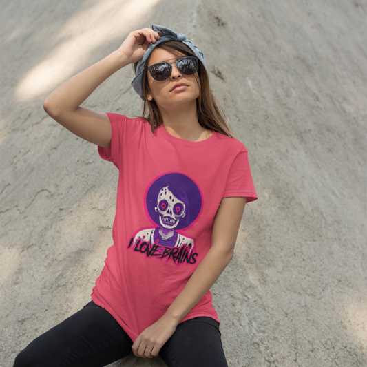 Woman wearing a pink t-shirt with a graphic design, sitting on a concrete surface.