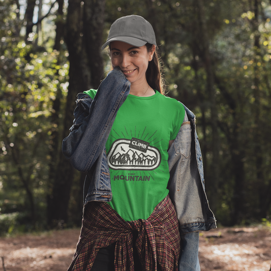 Woman in a green t-shirt with a logo, standing in a forest.
