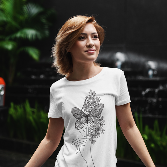 Woman wearing a white t-shirt with a black butterfly design outdoors.