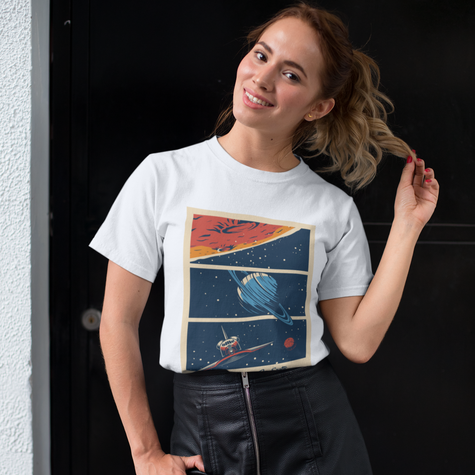 Woman wearing a white t-shirt with a colorful graphic design, standing against a black background.