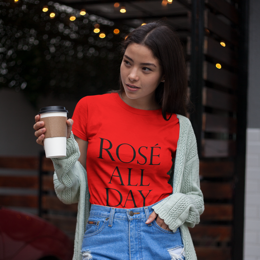 Woman wearing a red t-shirt with 'Rosé All Day' text, holding a coffee cup outdoors.