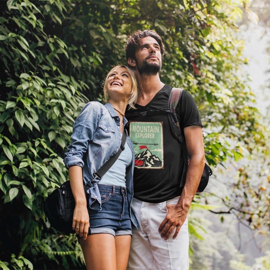 Two people standing in a forested area with greenery around them.